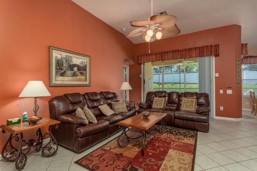 a living room with brown leather couches and tables at 2217 Wyndham Palms in Kissimmee