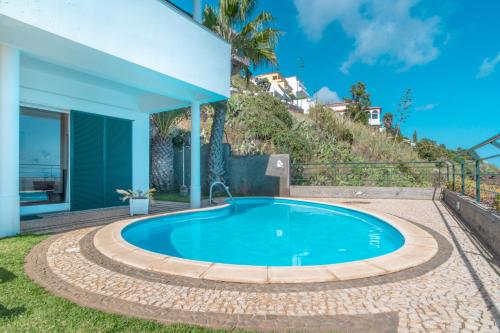 een zwembad in de achtertuin van een huis bij Villa Amelia in Falésia by the Sea in Caniço
