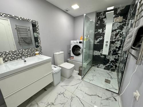 een badkamer met een douche, een toilet en een wasmachine bij Hotel complex house near the beach in Paphos City