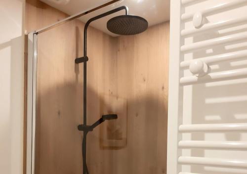 een douche in een badkamer met een lamp aan de muur bij Charmant Gîte à St-Cast in Saint-Cast-le-Guildo