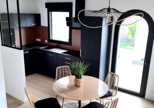 een keuken met een tafel met stoelen en een potplant bij Charmant Gîte à St-Cast in Saint-Cast-le-Guildo