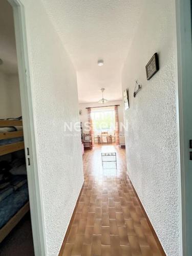 - un couloir avec un mur blanc et du parquet dans l'établissement 3086-Appartement 2pièces bien situé, à Argelès-sur-Mer