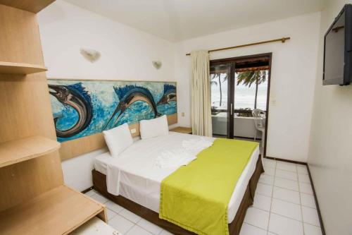 um quarto com uma cama e um quadro na parede em Pousada Caravelas de Pinzón em Cabo de Santo Agostinho