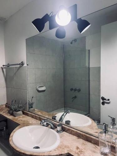 a bathroom with two sinks and a large mirror at Amplio Dpto. con Balcón y cochera cerca del Parque in Mendoza