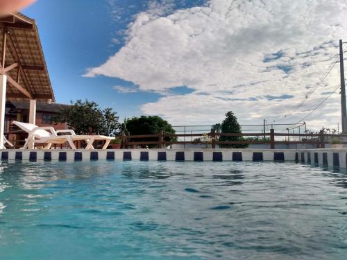 una piscina en un complejo bajo un cielo nublado en Casa 04 do Condomínio Privê Portal das Flores en Gravatá