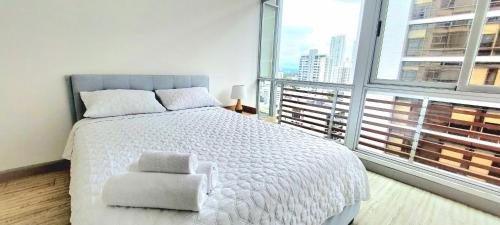 a bedroom with a white bed and a large window at Fascinating Apartment City Center - PH Quartier Atlapa in Panama City