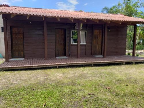 een klein houten huis met een veranda en een tuin bij Pousada Ilha das Peças LG in Fortaleza
