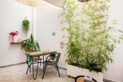 a table and chairs in a room with plants at Santa Triada in Heraklio