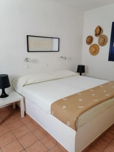 a white bed in a white room with two lamps at HONES - RELAX HOUSE in Perissa