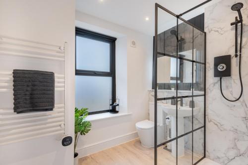 a bathroom with a glass shower stall and a toilet at Southend Cottage in Penrith