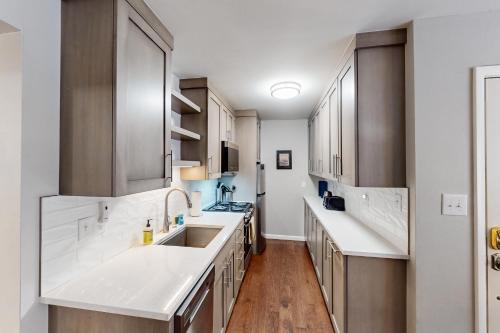 una cocina con encimeras blancas y armarios de madera en Vail East Unit 7, en Vail