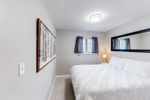 biała sypialnia z łóżkiem i 2 oknami w obiekcie Vail East Unit 7 w mieście Vail