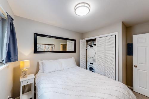 Un dormitorio con una cama blanca y un espejo. en Vail East Unit 7, en Vail