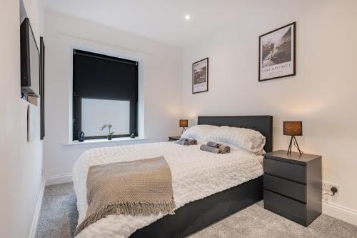 a bedroom with a large bed and a window at Southend Cottage in Penrith