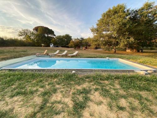 - une piscine avec 2 chaises longues dans un champ dans l'établissement Charme et confort à la campagne !, à Mauvezin-dʼArmagnac