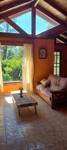 a bedroom with a bed and a table and a window at La Bellota in Villa Ventana