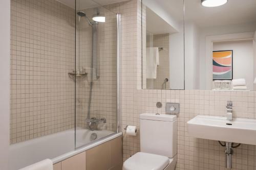 a bathroom with a toilet and a sink and a shower at Monarch House - Serviced Apartments - Kensington in London