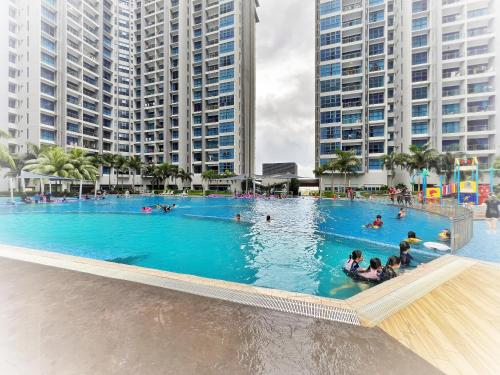 a large swimming pool with people in it with tall buildings at JZstay - Atlantis Residences Melaka - 1BR & 2BR in Melaka