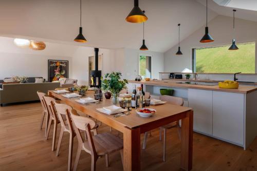 a kitchen and dining room with a wooden table and chairs at Villa Trois Lauriers - OVO Network in Écharvine