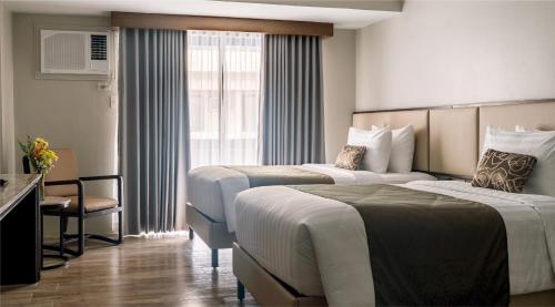 a hotel room with two beds and a window at Canyon Hotels & Resorts Boracay in Boracay