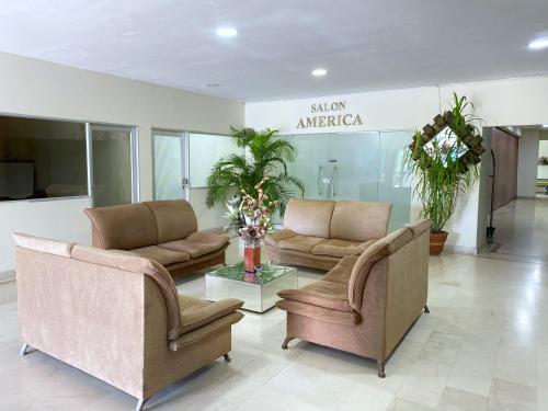 a lobby with two couches and a table in a building at Hotel Continental Plaza in Barranquilla