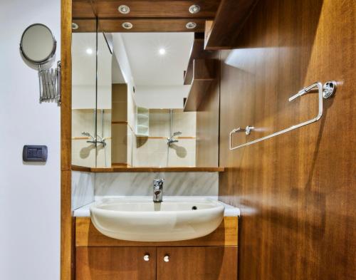 a bathroom with a sink and a mirror at Arc of Peace - Exclusive Apartment in Milan