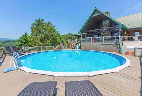 a pool on a deck with chairs and a building at Heaven’s View Lodge, Pool, Pet Friendly in Dunlap