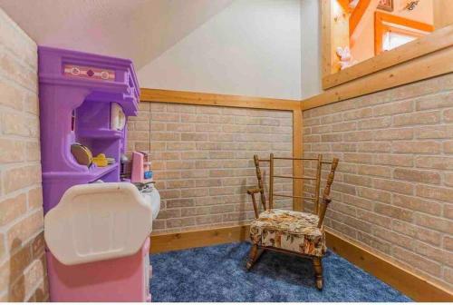 a bathroom with a pink toilet and a chair at Heaven’s View Lodge, Pool, Pet Friendly in Dunlap