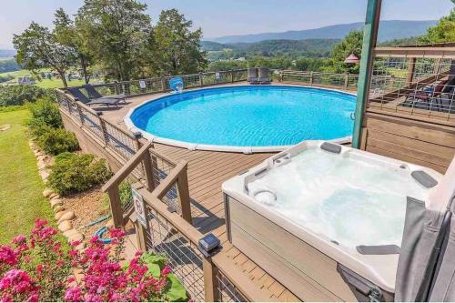 a hot tub on a deck next to a swimming pool at Heaven’s View Lodge, Pool, Pet Friendly in Dunlap