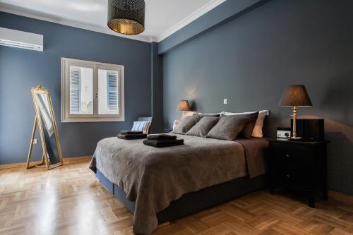 - une chambre avec des murs bleus et un grand lit dans l'établissement Luxurious apartment Kolonaki, à Athènes
