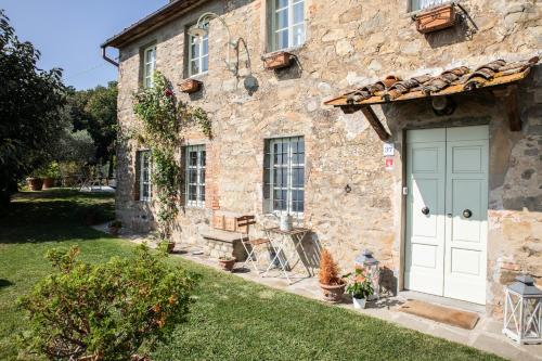 a stone house with a blue door and a yard at Villa Iris with Swimming Pool in Capannori