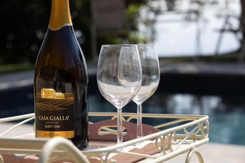 a bottle of wine and two wine glasses on a tray at Villa Iris with Swimming Pool in Capannori