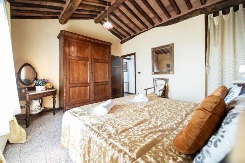 a bedroom with a bed and a wooden cabinet at Villa Iris with Swimming Pool in Capannori