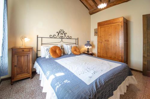a bedroom with a large bed and a wooden cabinet at Villa Iris with Swimming Pool in Capannori