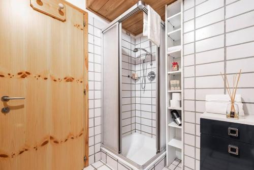 una ducha con puerta de cristal en un baño en Chalet Sassongher II, en Corvara in Badia