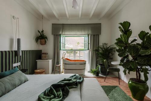 1 dormitorio con cama, bañera y ventana en Hotel Cesar Lanzarote en La Asomada