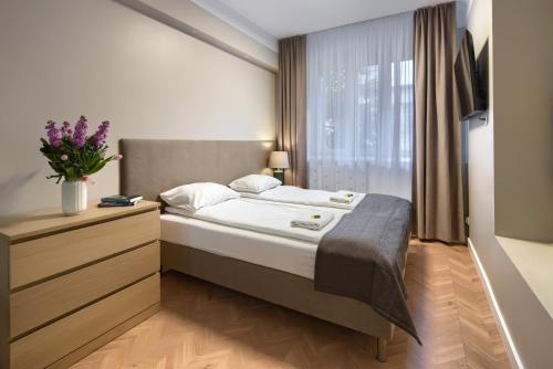 a bedroom with a large bed and a window at APARTEL Stary Mokotow SGH Metro & Tram in Warsaw