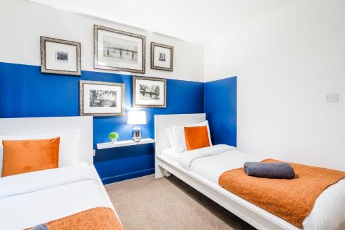 two beds in a room with blue walls at 4 guests 2 bedroom flat monthly stay offer by Comfy Nest in Derby