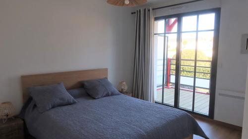 1 dormitorio con cama y ventana grande en Les Voiles du Clipper T2, en Préfailles