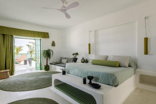 a bedroom with a bed and a living room at Hotel Cesar Lanzarote in La Asomada