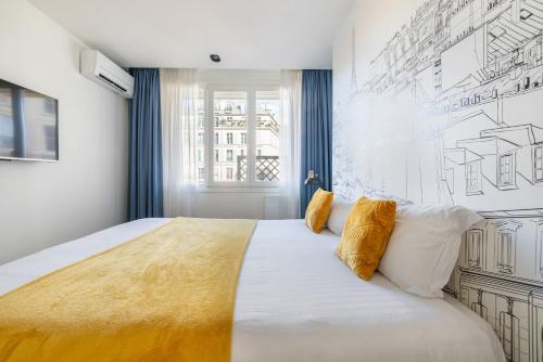 a bedroom with a large bed with yellow and white pillows at Atelier in Paris