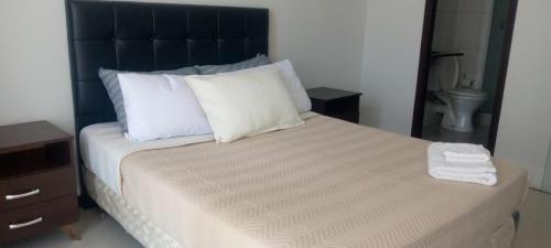 een slaapkamer met een groot bed met witte kussens bij Tranquilidad, Rincón Vivaldi in Vila El Carmen