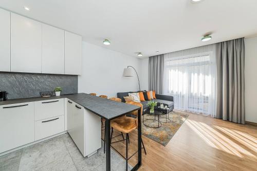 a kitchen and living room with a table and chairs at Lovely Apartment with Private Terrace by URBAN RENT in Kaunas