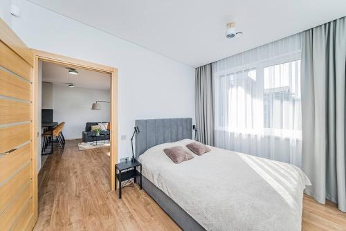 1 dormitorio con cama y ventana grande en Lovely Apartment with Private Terrace by URBAN RENT, en Kaunas
