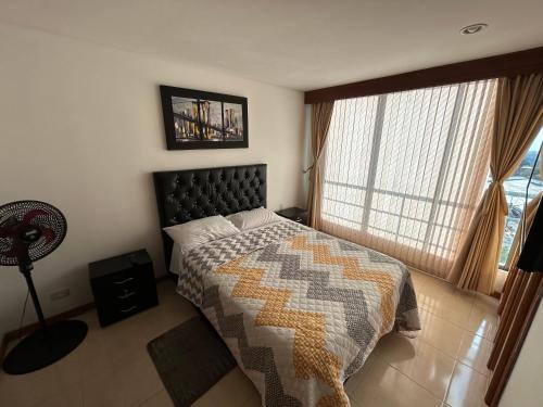 1 dormitorio con cama y ventana grande en santorini delauxe en Pereira