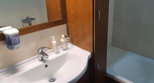 ein Waschbecken mit einem Spiegel und einer Dusche in der Unterkunft BLUE LUXURY APARTMENT (BREAKBOOKING CY-SERVICES LTD) in Limassol