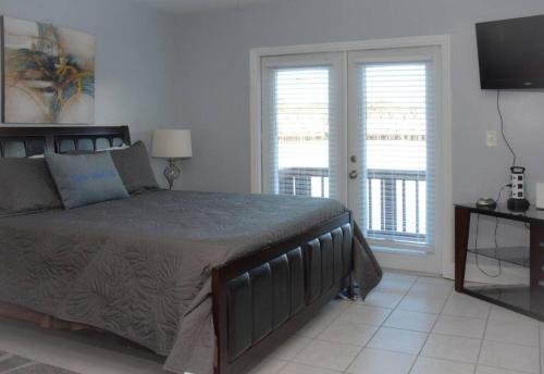 a bedroom with a large bed and a television at Scenic Carolina Waterfront Rentals - Arco in Charleston