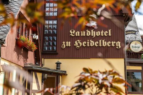 a sign for a restaurant on the side of a building at Landhotel zu Heidelberg in Seiffen