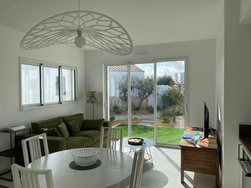 a living room with a table and a couch at Maison neuve zone coulée verte menant a l'océan in Saint-Gilles-Croix-de-Vie