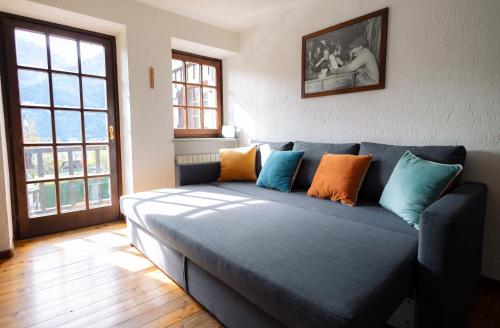 niebieska kanapa z kolorowymi poduszkami w salonie w obiekcie tHE Mountain View Lodge w mieście Courmayeur